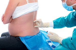 pregnant woman getting an epidural from a doctor Gray and White Law